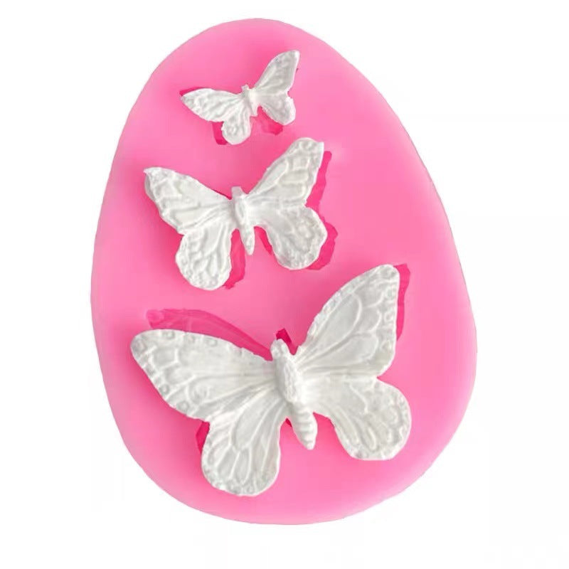 Pink silicone mold with white butterfly shapes on a white background